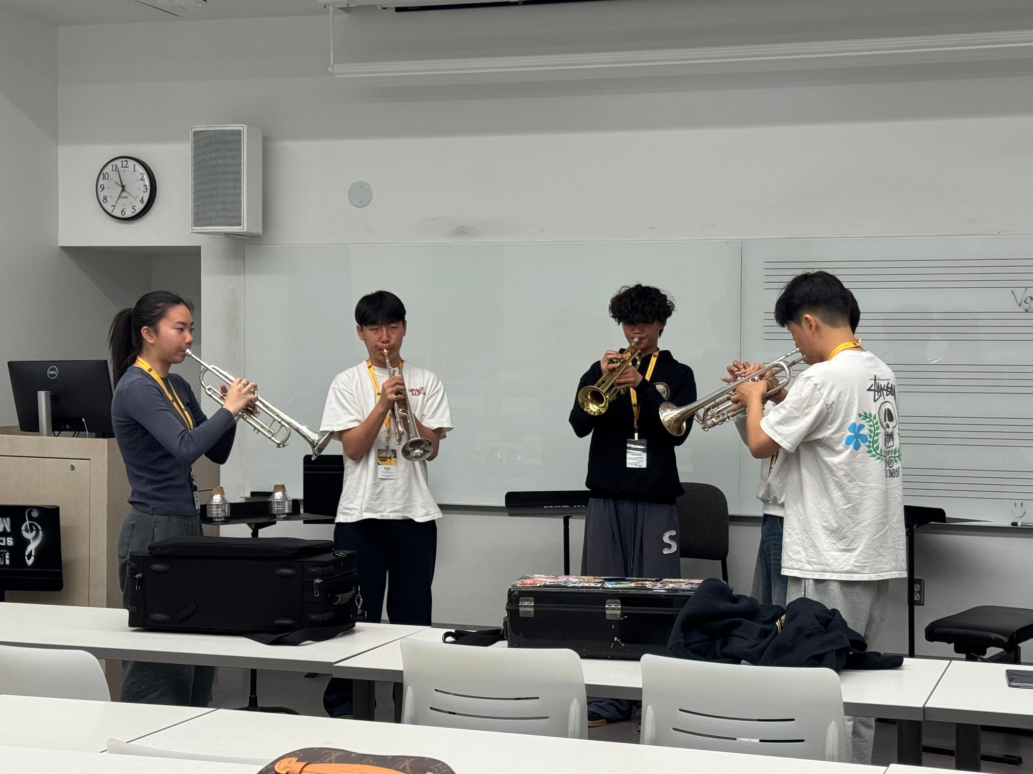 Four students playing trumpets in masterclass