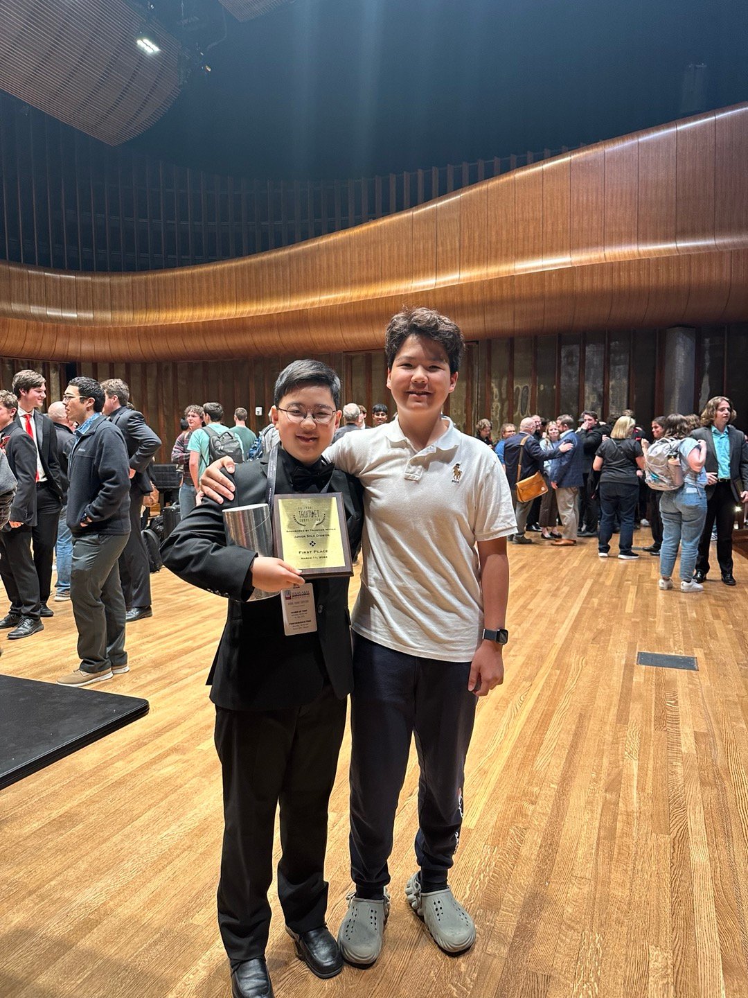 Two students celebrating with NTC First Place award in concert hall