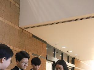 Students reviewing music with Matthew Kim in hallway before performance
