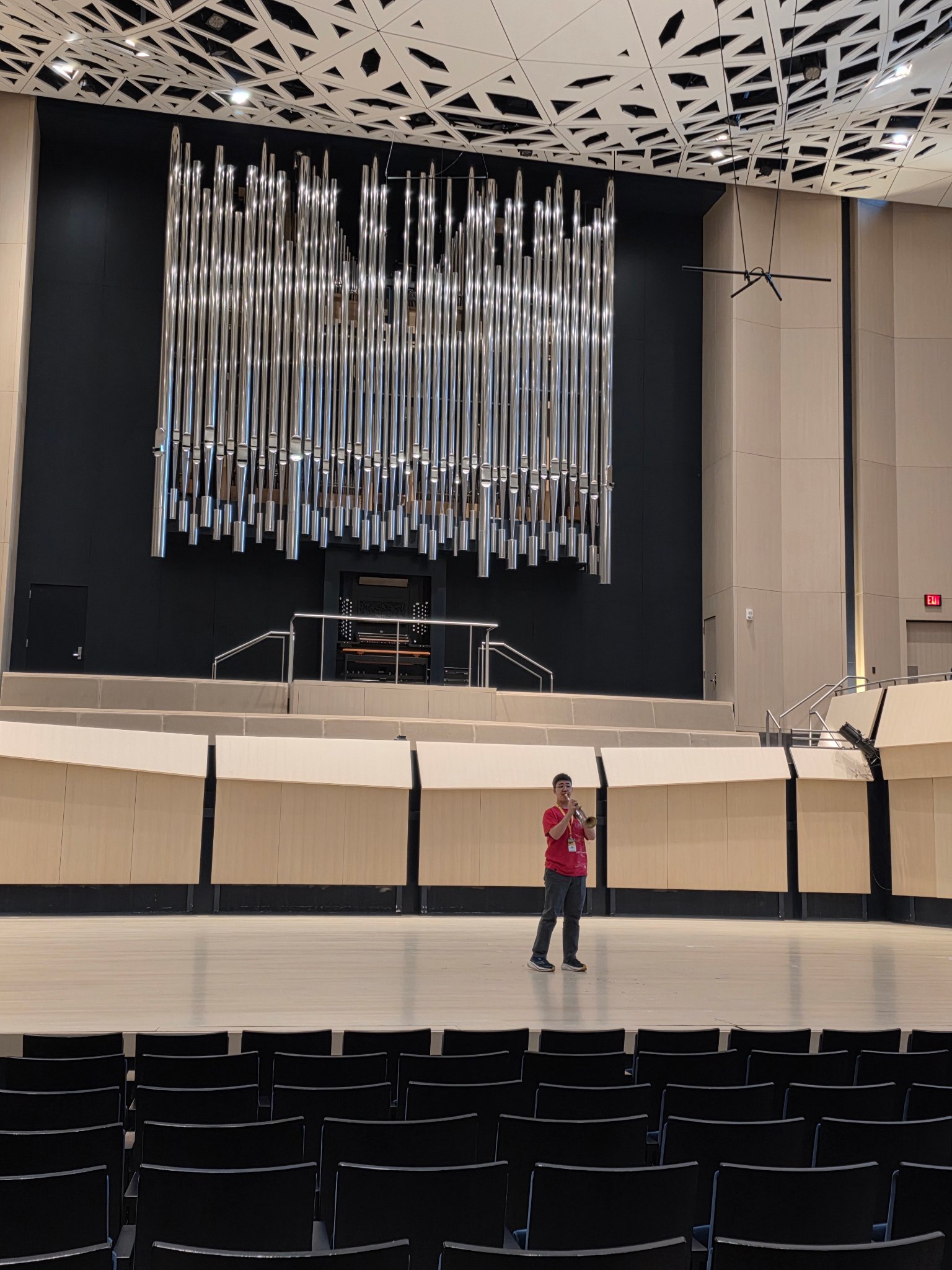 Student performing trumpet on stage at NTC venue with pipe organ backdrop