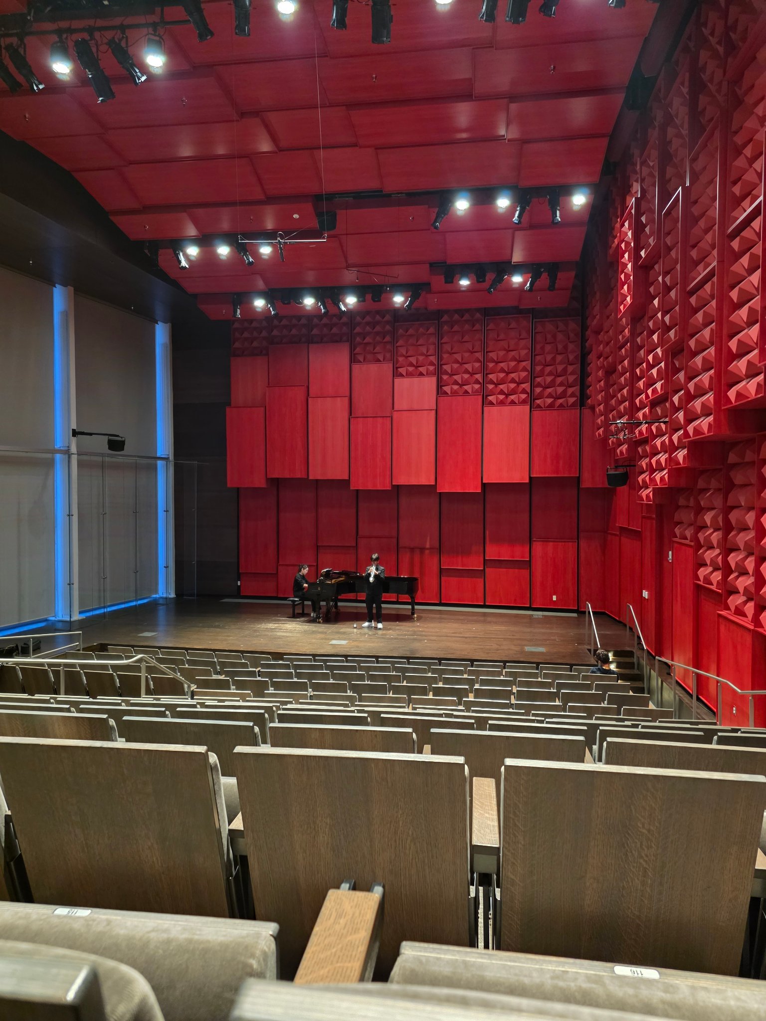 Trumpet duo performing in red concert hall