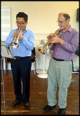 Matthew Kim with trumpet artist outdoors